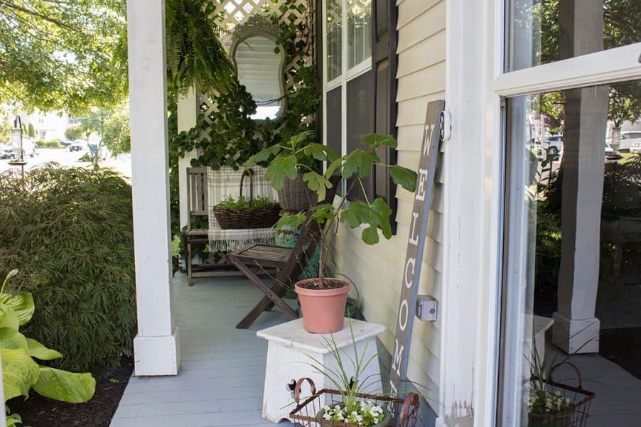 Small front porch, painted concrete, privacy trellis with vine and outdoor mirror...SO cute!