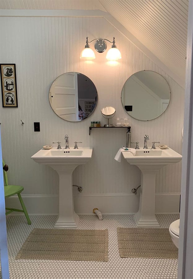 bathroom with double pedestal sinks, slanted ceilings, penny tile floor, attic bedroom