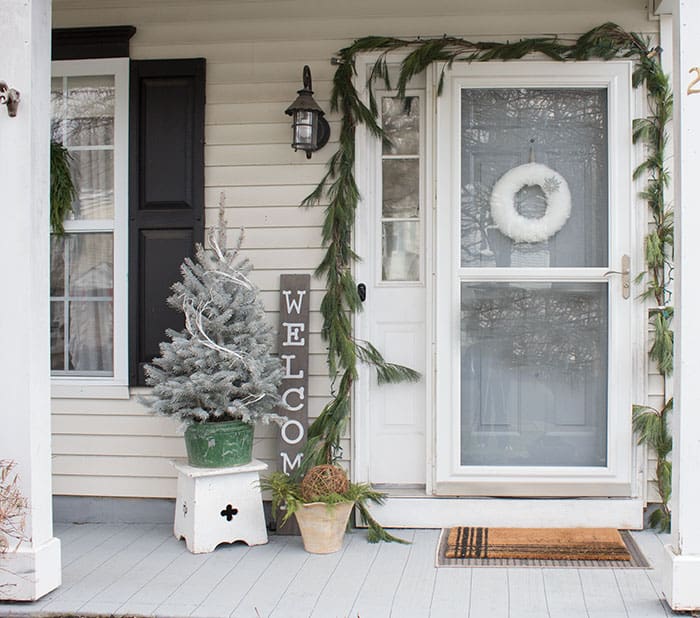 Pine garland hung around front door exterior.