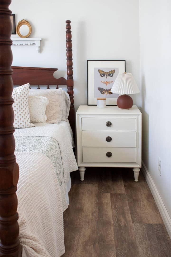 white bedroom with dark vinyl plank flooring