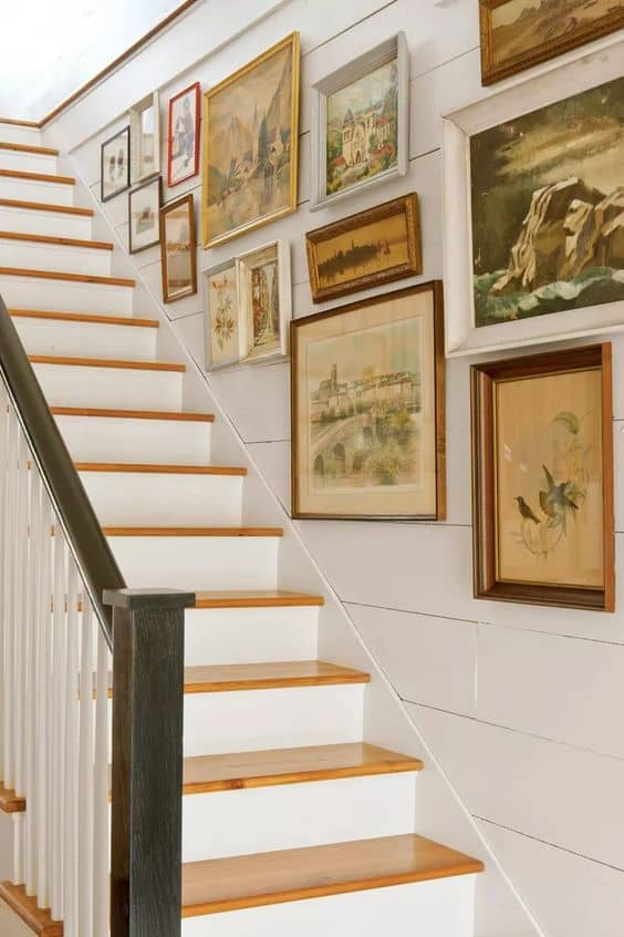 gallery wall of vintage art in staircase