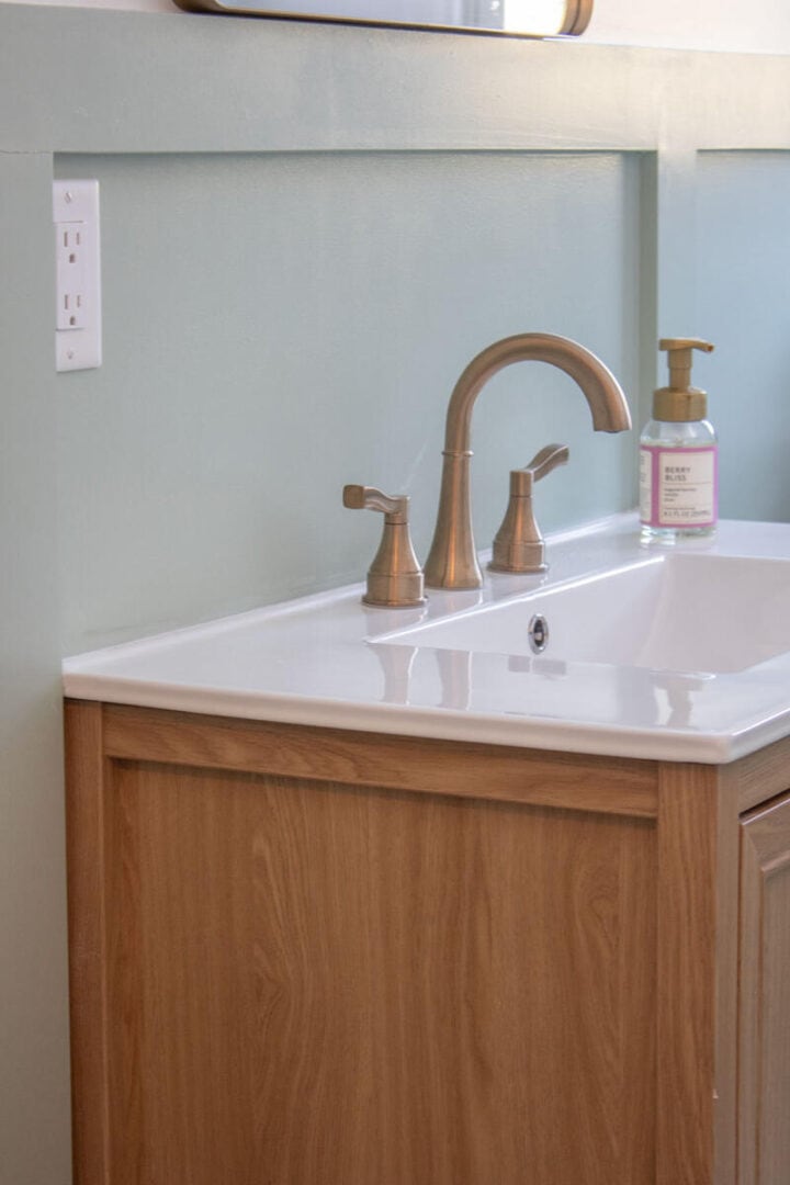 green-bathroom-with-brass-hardware-and-faucet